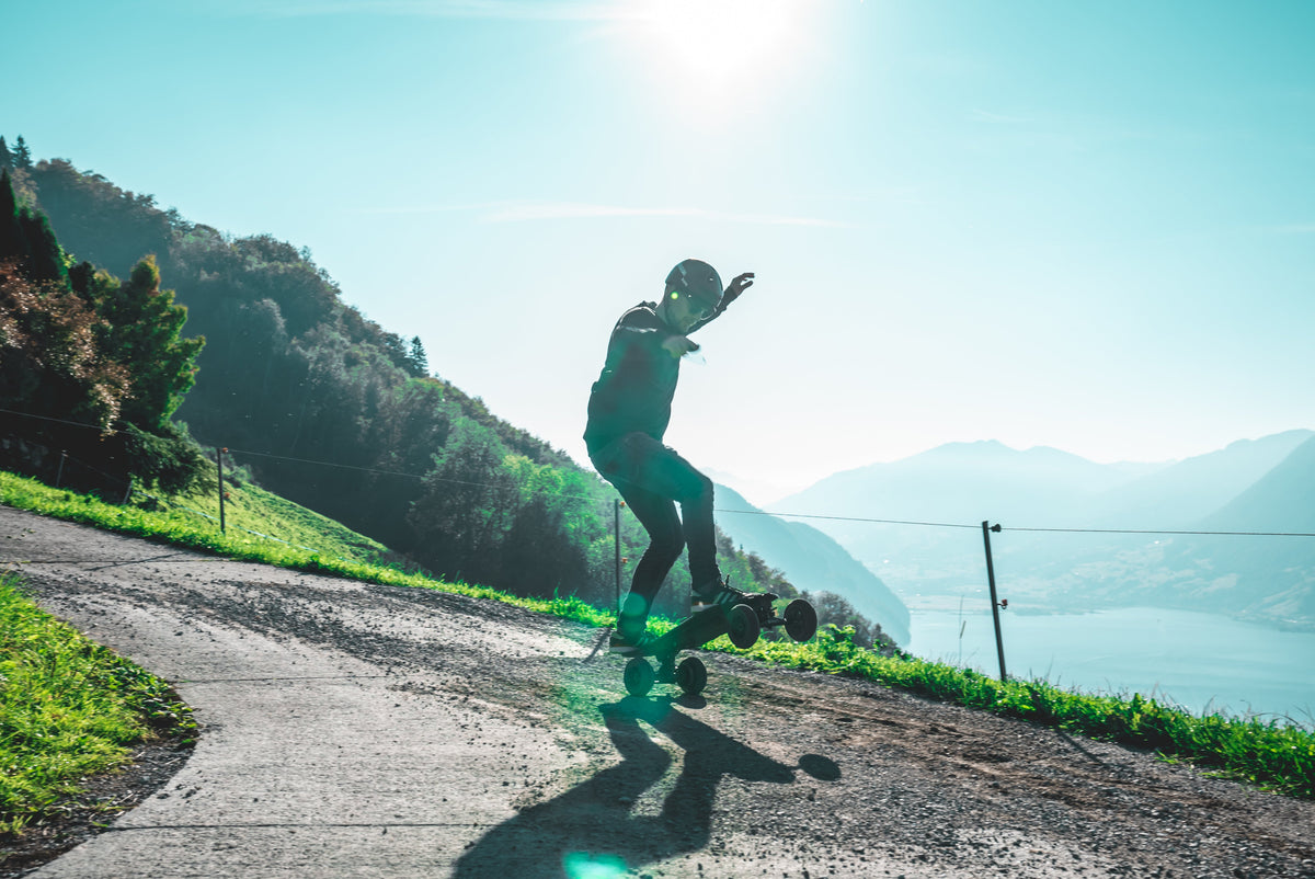 Rider on the ONSRA Challenger Pro All-Terrain on a mountain road by a lake