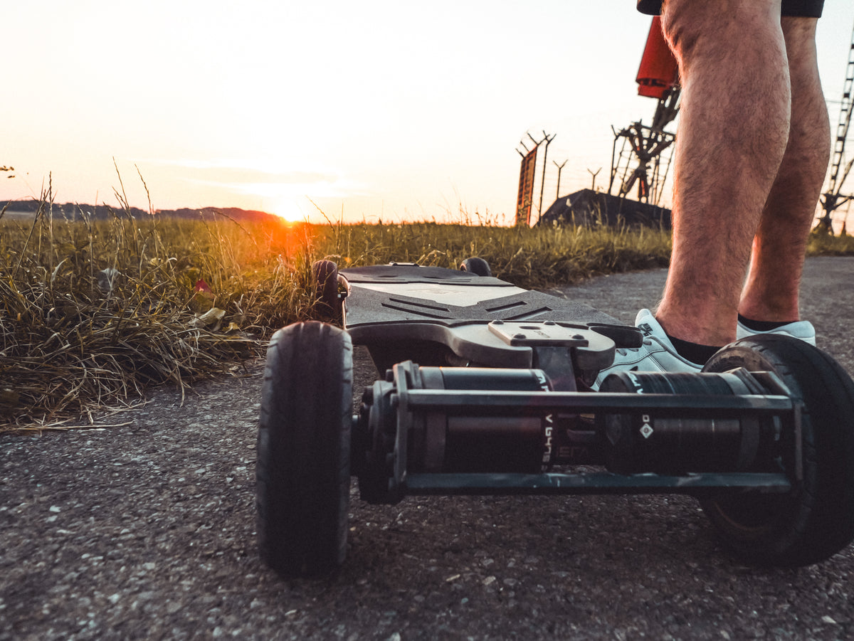 Rider standing on an ONSRA BLACK CARVE 4 at sunset