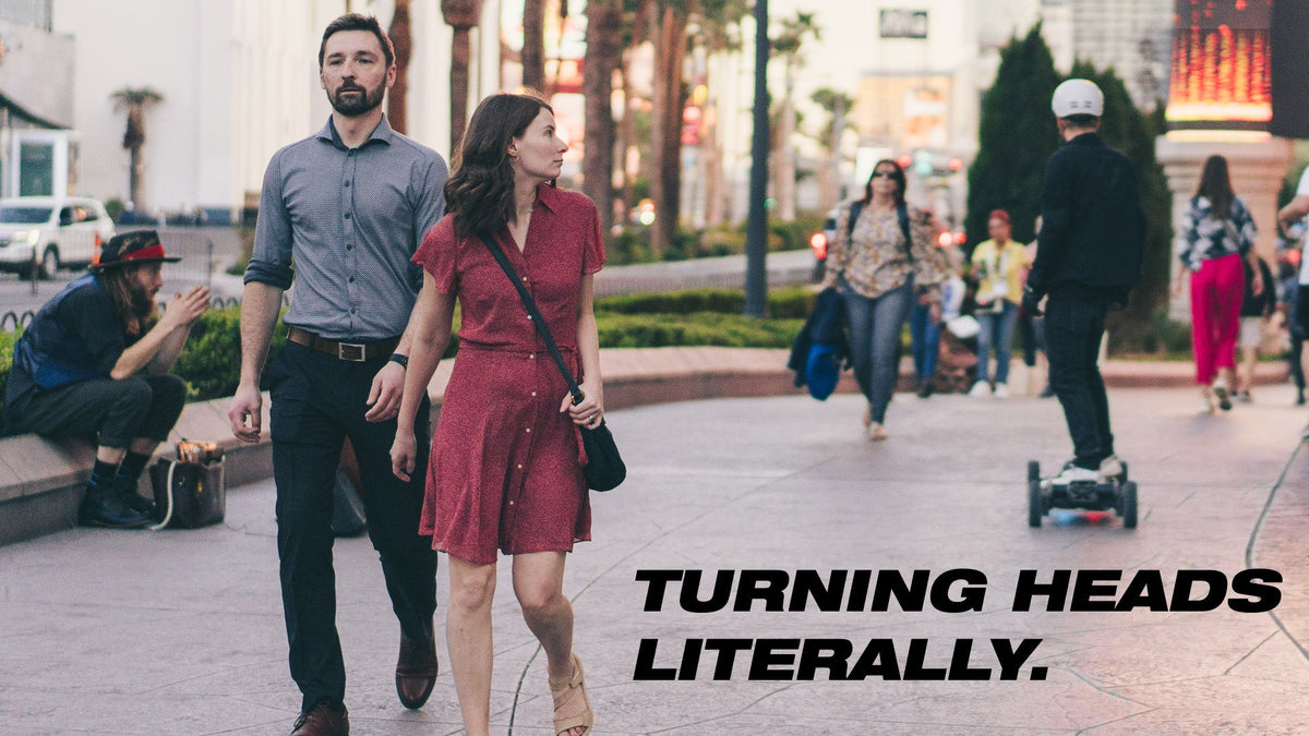 Passers-by watching an ONSRA VELAR rider on a city street – "Turning heads. Literally."